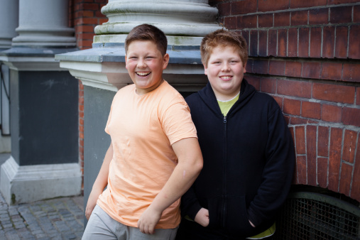Amistad: Sobrepeso dos chicos adolescentes en frente de su escuela photo
