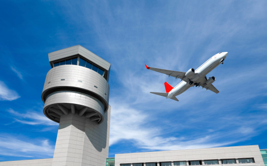 Airplane and Control Tower. Plane flying past control tower
