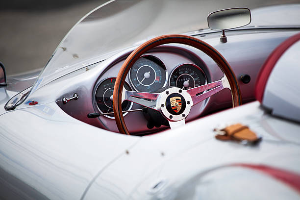 Beck Porsche 550 Spyder Halifax, Nova Scotia, Canada - June 16, 2012: At a public car gathering, a Porsche 550 Spyder replica interior. Focus on steering wheel with instrument panel and dash mounted rearview mirror visible inside the car. Asphaly surface visible in front of car and out of focus.  The 550 Spyder is one of the most replicated of classic automobiles with numerous companies creating almost exact replicas of the car. vintage steering wheel stock pictures, royalty-free photos & images