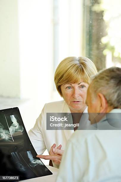 Specialista Spiega I Raggi X Per Il Paziente - Fotografie stock e altre immagini di Caviglia - Caviglia, Immagine a raggi X, Medico