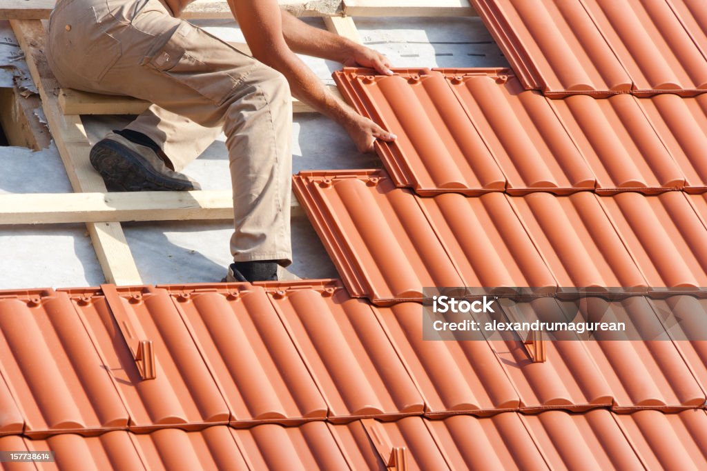 Homem trabalhando no telhado - Foto de stock de Telhador royalty-free Homem trabalhando no telhado - Foto de stock de Telhador royalty-free