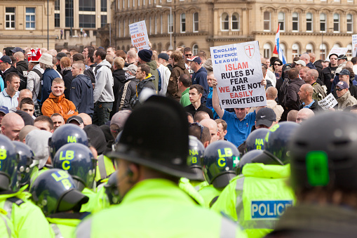 Bradford, UK - August 28, 2010: Protestors holding up  banners at the English Defence League rally in the centre of Bradford. The EDL are a far right group who held a rally in the city of Bradford, which has a large muslim population. Although the EDL said that thousands would join them, only around 800 showed up on the day, according to police estimates.