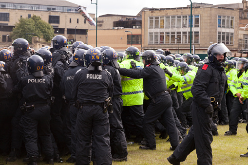 Bradford, UK - August 28, 2010: Police in riot gear form a line to contain protestors at the English Defence League rally in Bradford. The EDL, a far right group, held a rally in the city of Bradford which has a large Muslim population.
