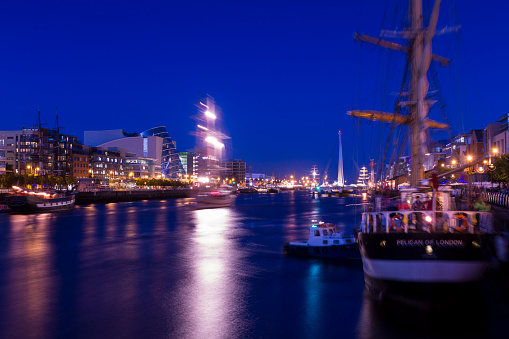 Dublin, Ireland - August 21st, 2012: View over river Liffey during Tall Ship Race event, tall ship 'Pelican of London' in the foreground ready for the race in two days. Samuel Beckett bridge has been open to let all ships enter the Liffey.