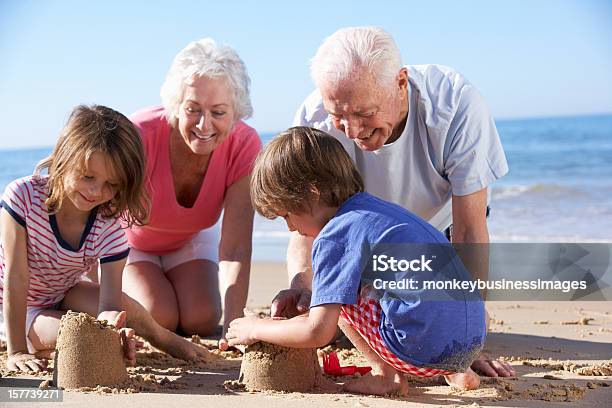 祖父母と孫ビルビーチで砂の城 - 砂城のストックフォトや画像を多数ご用意 - 砂城, 祖父母, 浜辺