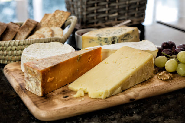 Selection of English and French Cheese on Rustic board stock photo