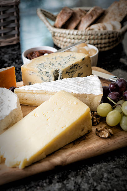 Selection of English and French Cheese on Rustic board stock photo