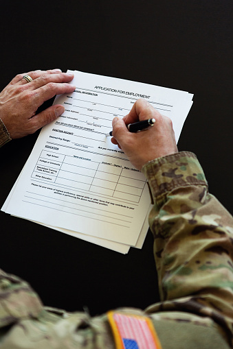 Unrecognizable American soldier filling out a job application form