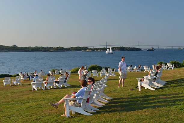 Boats moored in a harbor in front of the Claiborne Pell Newport bridge on a sunny day.