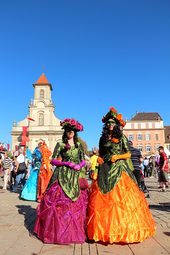 Ludwigsburg, Germany - September 8, 2012: A scene of the Venezianische Messe (Venetian Fair), a carnival event in honour of the Venetian Carnival in Italy. Two women in beautiful carnival costume posing to photographer on the marketplace in Ludwigsburg/Germany on a sunny day in September 2012. More people in the background.