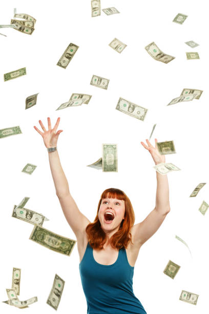 istock Overjoyed young redhead catching shower of falling banknotes 157740058