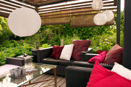 A garden patio with wicker sofas surrounded by trees