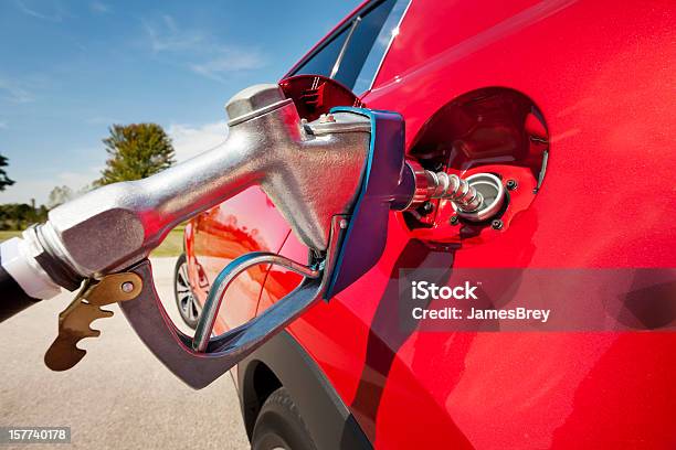 Echando Gasolina En Rojo Vehículo Foto de stock y más banco de imágenes de Gasolina - Gasolina, Interior del coche, Bomba de combustible