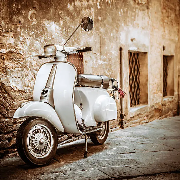 Vespa scooter in an old alley of Siena (Tuscany, Italy).