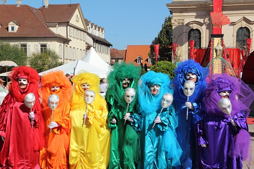 Ludwigsburg, Germany - September 8, 2012: A scene of the Venezianische Messe (Venetian Fair), a carnival event in honour of the Venetian Carnival in Italy. You can see colorful dressed people with carnival costume in rainbow colors in front of the church on the marketplace in Ludwigsburg/Germany.