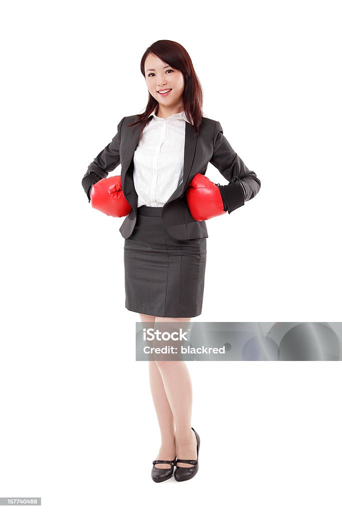 Asian Businesswoman in Boxing Gloves on White Background Young attractive Asian businesswoman in boxing gloves, showing a winning gesture, isolated on white background. Boxing - Sport Stock Photo