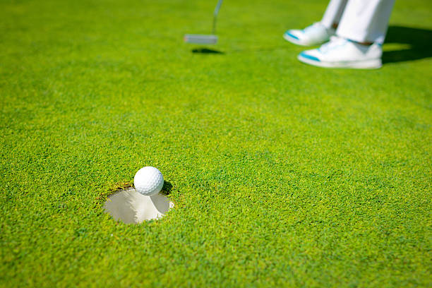 ビンゴます。ゴルファー正確にパッティング練習用ゴルフボールの穴 - golf golf course putting men ストックフォトと画像