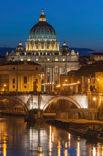 Rome, Italy - September 13 2014: View of Ponte Sant'Angelo (St. Angelo Bridge) that spans the Tiber river, with the dome of Saint Peter's Basilica in the background.