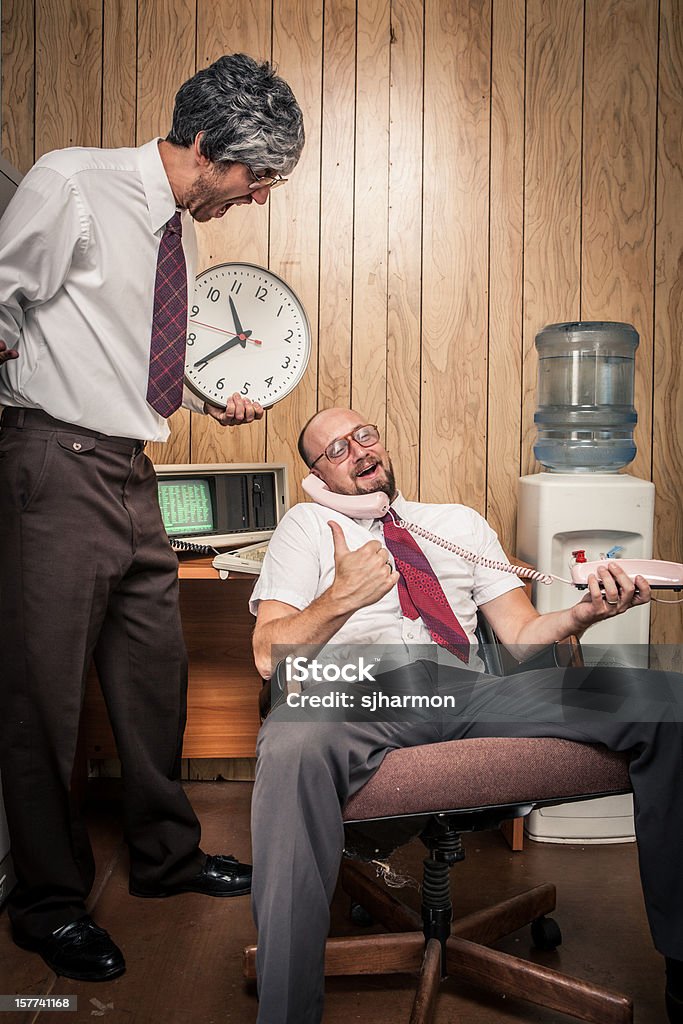 Disturbi retrò office manager urla alla fine del dipendente con clock - Foto stock royalty-free di Ufficio