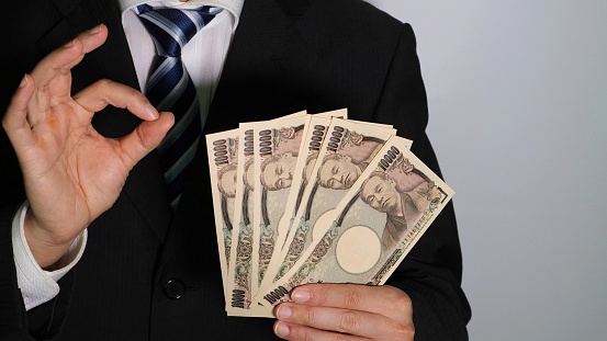 Photo of a businessman posing with banknotes