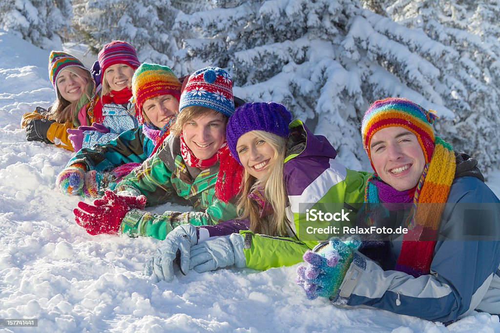 Groupe de happy people allongé sur la neige dans la forêt - Photo de Activité de loisirs libre de droits