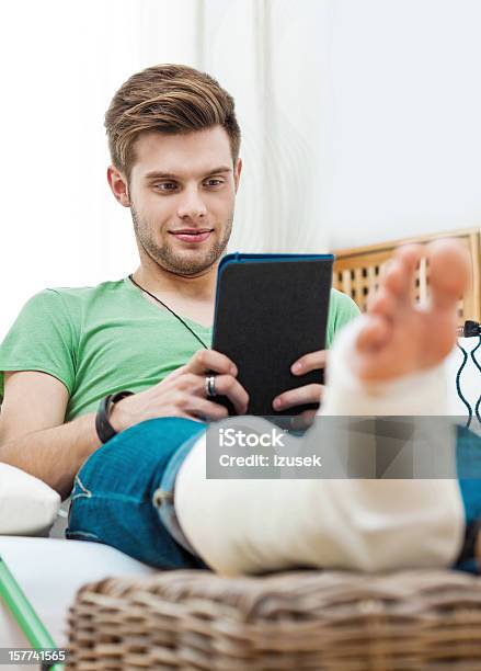 Young Man With Broken Leg At Home Stock Photo - Download Image Now - Home Interior, Men, Orthopedic Cast