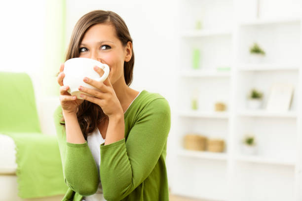 hermosa mujer disfruta de una taza de café en su casa - white green indoors studio shot fotografías e imágenes de stock