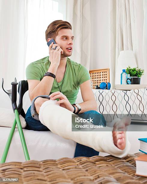 Young Man With Broken Leg At Home Stock Photo - Download Image Now - Orthopedic Cast, Bone Fracture, Men