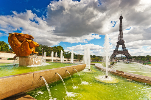 Eiffel tower in Paris viewed across the River Seine from the Trocadero Quarter with the fountains in the foreground and the green pools.