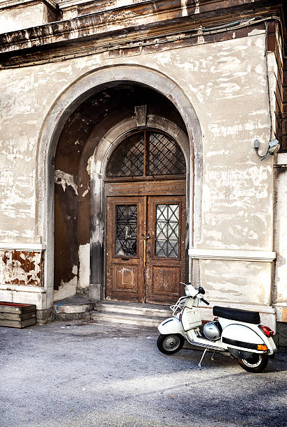 Scooter in front of a weathered door - typical italian street scene
