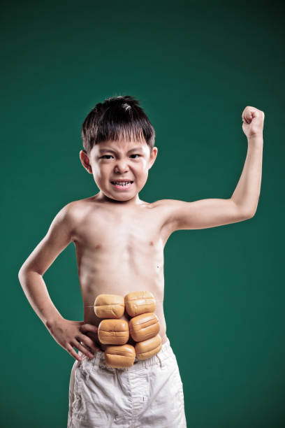 little boy imagina que ha conseguido gran músculo. - macho little boys flexing muscles human muscle fotografías e imágenes de stock