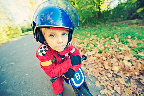 śmieszne mały rower racer - child playing dressing up imagination zdjęcia i obrazy z banku zdjęć