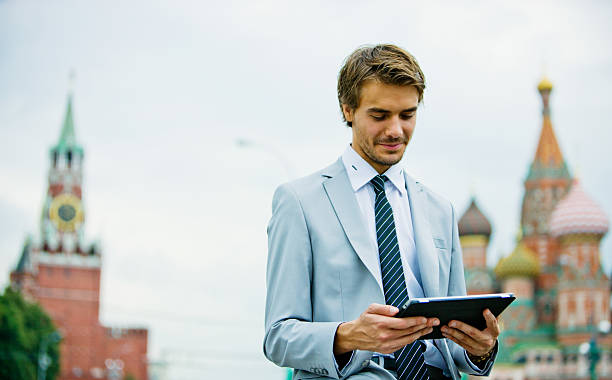 モスクワでハンサムな若い実業家デジタルタブレットを手 - moscow russia ストックフォトと画像