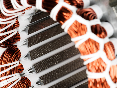 Detail of copper winding and stack of an electric induction motor for home appliances. Selective focus.