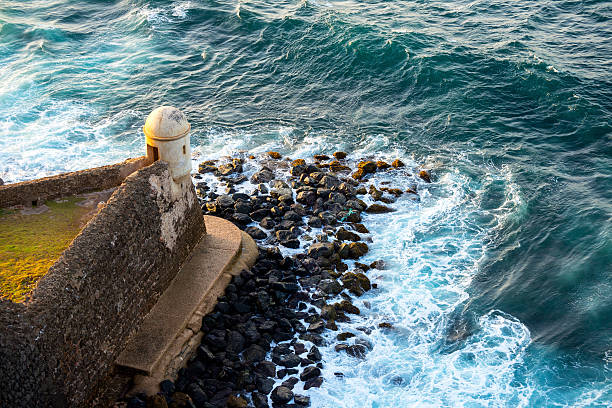 Fort and sea in Puerto Rico Waves crash against the base of Castillo San Felipe del Morro, a 16th-century Spanish fort in San Juan, Puerto Rico puerto rico photos stock pictures, royalty-free photos & images