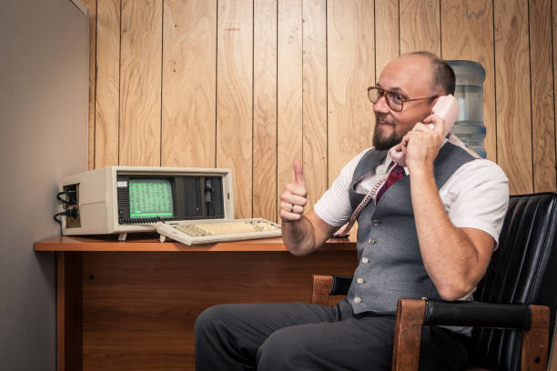 istock excited 1980's computer worker nerd  on phone at cubicle 157742677