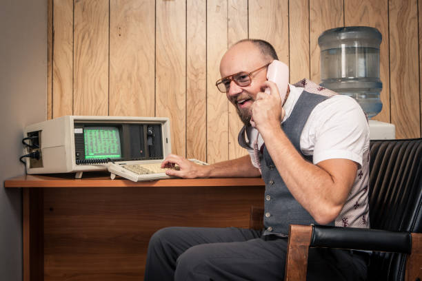 istock Happy 1980's computer worker nerd  on phone at cubicle 157742678