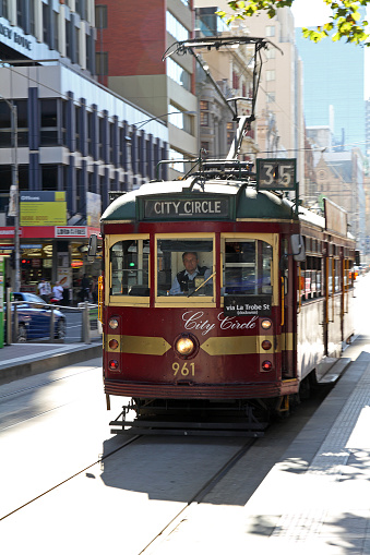 A TTC streetcar moves up Spadina Avenue in downtown Toronto, with the CN Tower seen in the background. Pictured in the fall, autumn and on a clear day.