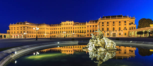 Schönbrunn Palace, Vienna Vienna, Austria - September 9, 2012: It's dusk and only few people are still strolling in the Schonbrunn Palace park. They are the last of the usual crowd of people who every day visit this magnificent palace, which in earlier times was the summer residence to various Habsburg rulers. Its surrounding buildings and the huge park have been added to the UNESCO's world cultural heritage list in 1996. vienna austria photos stock pictures, royalty-free photos & images
