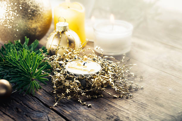 candle  and green fir branch, bauble on wooden background