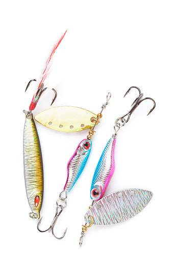 Set of metal lures for fishing shot on white surface