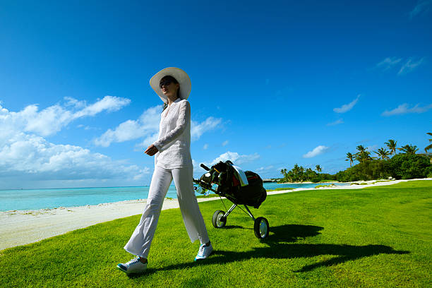 istock Female Golfer With Cart Walking On Beach Golf Course 157743633