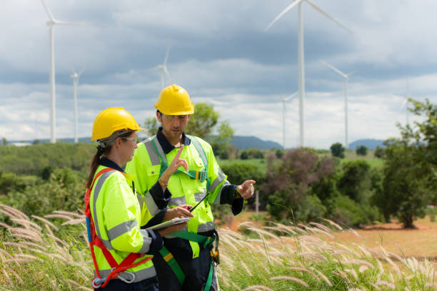 istock Engineer and worker discussing the project on the background of wind turbines 1577575695