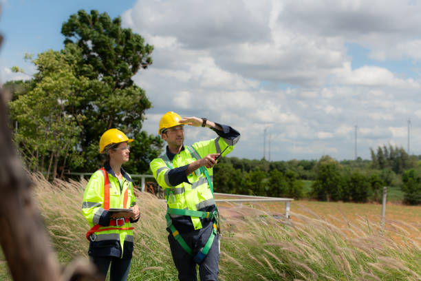 Engineer and worker discussing the project on the background of wind turbines