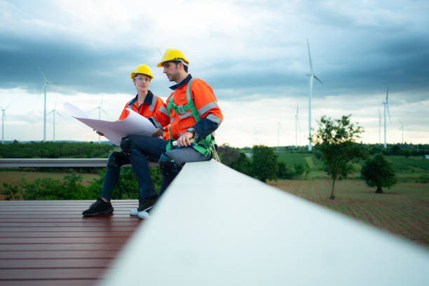 istock Engineer and technician discussing blueprint on the building site with wind turbine background 1577576030