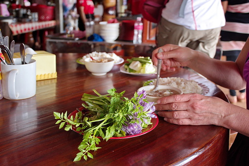 Midsection of woman eating traditional Cambodian food