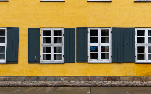 White and green window on yellow wall.