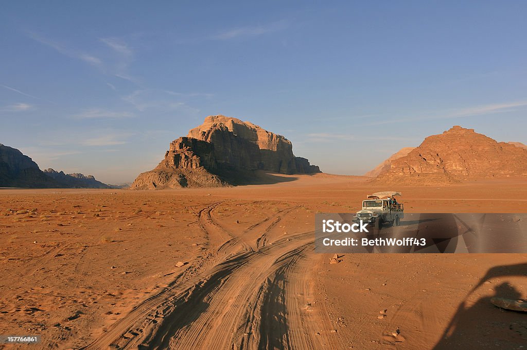 Wadi Rum at Sunset A caravan of jeeps in Wadi Rum Jordan are racing across the desert to get to a special place to see the sunset.  Wadi Rum Stock Photo