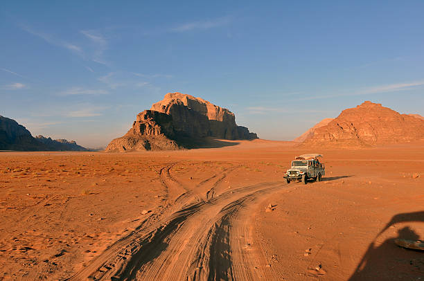 Wadi Rum at Sunset A caravan of jeeps in Wadi Rum Jordan are racing across the desert to get to a special place to see the sunset.  akaba stock pictures, royalty-free photos & images