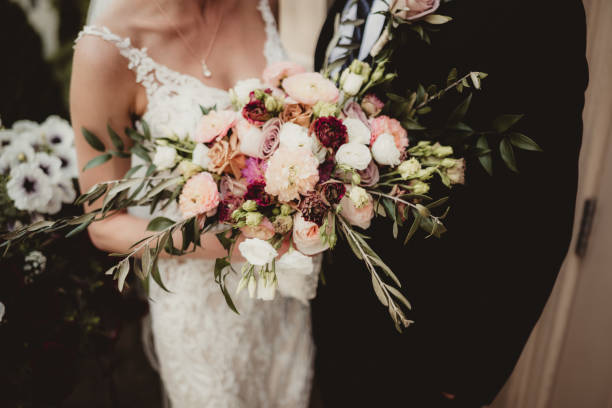 istock Bride and groom holding floral wedding bouquet 1577682247